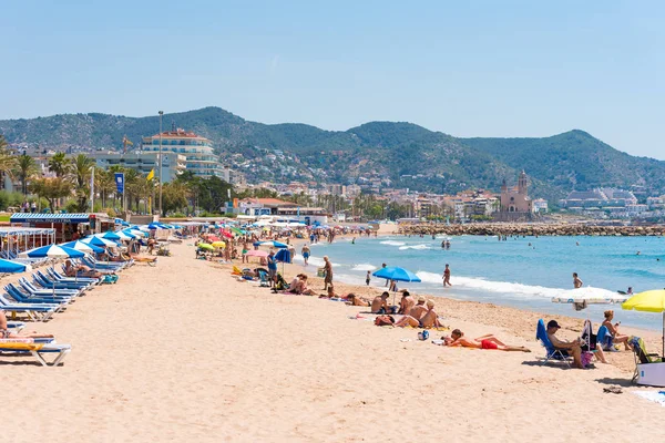 SITGES, CATALUNIA, ESPAÑA - 20 DE JUNIO DE 2017: Vista de la playa de arena. Copia espacio para texto. Aislado sobre fondo azul . — Foto de Stock