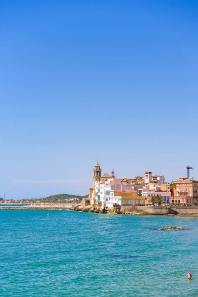 Sitges, Catalunya, İspanya - 20 Haziran 2017: Tarihi merkezi ve Sant Bartomeu kilise ve Santa Tecla görünümü. Metin için yer kopyalayın. Üzerinde mavi arka plan izole. Dikey.