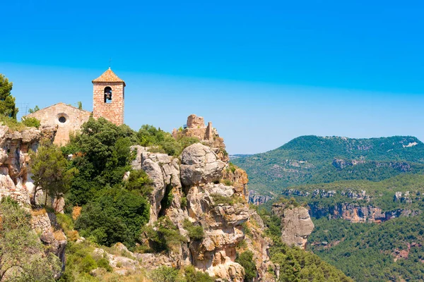 Nézd a román stílusú templom, a Santa Maria de Siurana, Siurana de Prades, Tarragona, Catalunya, Spanyolország. Másol szöveg adható. Elszigetelt, a kék háttér. — Stock Fotó