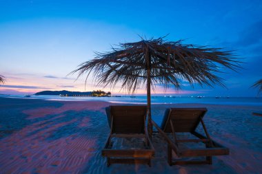 Sahilde şezlong şemsiye ile gün batımı. Metin için yer kopyalayın.