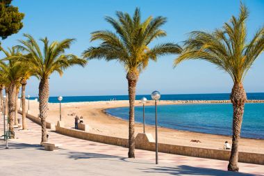 Miami Platja, İspanya - 24 Nisan 2017: Dolgu, kumlu bir plaj ve güzel palmiye ağaçları.