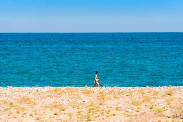 Miami Platja, Španělsko - 24. dubna 2017: Žena kráčí podél pobřeží. Kopírovat prostor pro text. — Stock fotografie