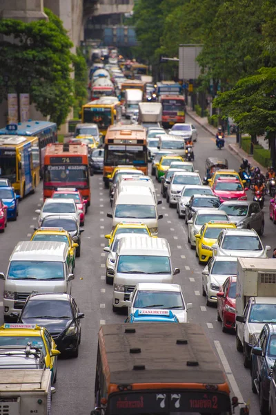 BANGKOK, THAILANDIA - 28 NOVEMBRE 2016: Veicoli (moto, autobus, auto e taxi) aspettano un semaforo verde all'incrocio con passerella sulla strada cittadina. Verticale . — Foto Stock