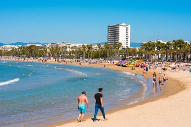 Salou, Tarragona, İspanya - 24 Nisan 2017: Costa Dorada plaj boyunca insanlar yürürken, insanlar. Metin için yer kopyalayın.