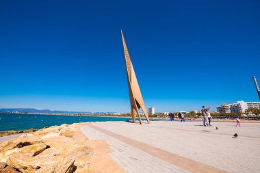 Salou, Tarragona, İspanya - 24 Nisan 2017: Turist ve kuşlar Costa Dorada sahilinde Yaylası girişindeki nitelikli anıt yakın. Mavi gökyüzü. Metin için yer kopyalayın.