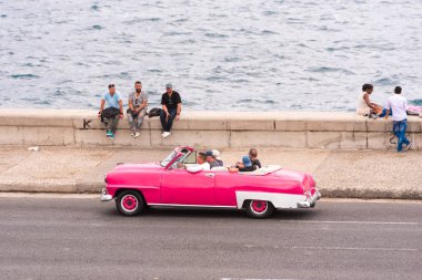 Küba, Havana - 5 Mayıs 2017: Amerikan pembe retro cabriolet ile Malecón sahil gidiyor. Metin için yer kopyalayın.