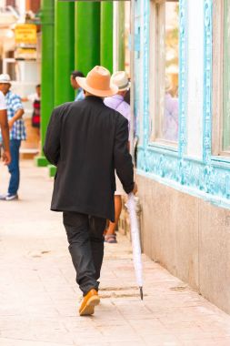 Adamın bir şapka ve bir şemsiye ile sokakta, Havana, Küba'da girer. Dikey. Metin için yer kopyalayın.