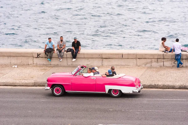Kuba, Havanna - 5. Mai 2017: Amerikanisches rosafarbenes Retro-Cabrio fährt die malecon-Strandpromenade entlang. Kopierraum für Text. — Stockfoto