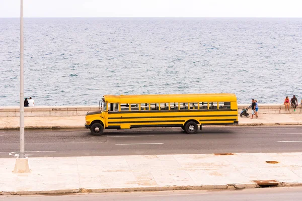 Kuba, Havana - 5. května 2017: Americký školní autobus jezdí po městských nábřeží. Kopírovat prostor pro text. — Stock fotografie