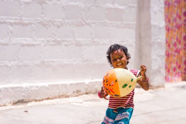 Puttaparthi, Andhra Pradesh, Hindistan - 9 Temmuz 2017: sokakta oynarken mutlu Hintli kız. Metin için yer kopyalayın.                