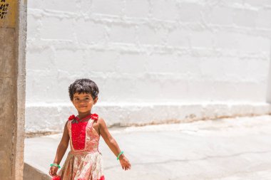 Puttaparthi, Andhra Pradesh, Hindistan - 9 Temmuz 2017: sokakta oynarken mutlu Hintli kız. Metin için yer kopyalayın.                