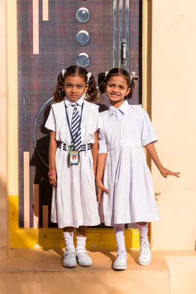 Puttaparthi, Andhra Pradesh, Hindistan - 9 Temmuz 2017: İki küçük Hintli kız okul üniformalı. Dikey. Metin için yer kopyalayın.