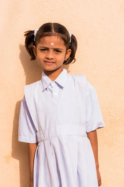 Puttaparthi, Andhra Pradesh, Hindistan - 9 Temmuz 2017: Beyaz elbiseli şirin bir Hintli kız portresi. Yakın çekim. Dikey.