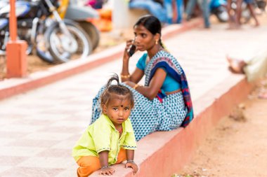 Puttaparthi, Andhra Pradesh, Hindistan - 9 Temmuz 2017: Küçük Hintli kız anne ile yolda. Metin için yer kopyalayın.