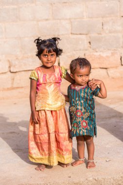 Puttaparthi, Andhra Pradesh, Hindistan - 9 Temmuz 2017: İki Hintli kızlar kapınıza bir evin bir çocukla. Metin için yer kopyalayın. 