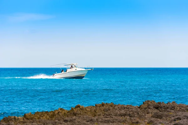 Bayahibe, La Altagracia, Dominik Cumhuriyeti deniz üzerinde beyaz bir tekne yelken. Metin için yer kopyalayın.