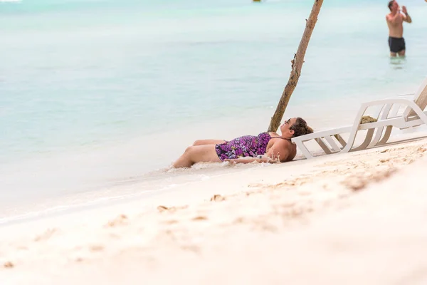 Саона, Домініканська Республіка - 25 травня 2017: товста жінка, лежачи на пляжі. Копія простір для тексту. — стокове фото