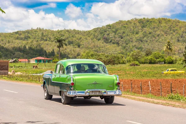 Vinales, Kuba - 13 maja 2017: Amerykański zielony samochód retro jeździ po drodze. Kopiować miejsca na tekst. — Zdjęcie stockowe