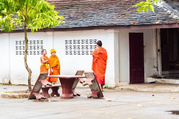 Louangphabang, Laos - 11. ledna 2017: Mniši na nádvoří chrámu. Kopírovat prostor pro text. — Stock fotografie