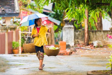 Louangphabang, Laos - 11 Ocak 2017: sokakta yürürken bir kadın sepetleri ile. Metin için yer kopyalayın.