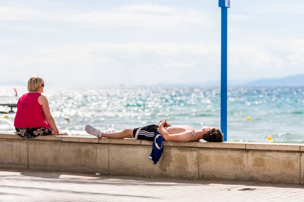 Salou, Tarragona, Španělsko - 17 září 2017: Muž leží na nábřeží v Salou. Kopírovat prostor pro text. — Stock fotografie