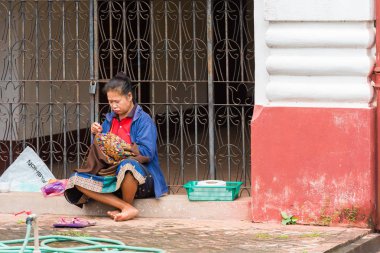 Louangphabang, Laos - 11 Ocak 2017: Kadın bir şehir sokak diker. Metin için yer kopyalayın. 