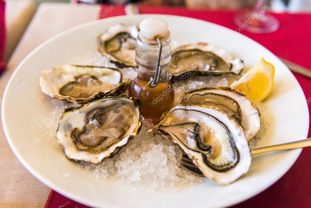 Oysters with lemon on a plate, Sete, France. Close-up.
