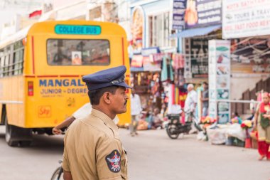 PUTTAPARTHI, ANDHRA PRADESH, INDIA - JULY 9, 2017: Police officer close-up on blurred background. Copy space for text. clipart