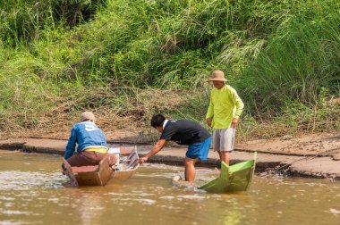 Louangphabang, Laos - 11 Ocak 2017: Üç adamla Nam Han Nehri üzerinde tekne. Metin için yer kopyalayın.