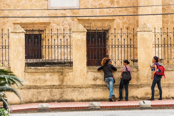 SANTO DOMINGO, REPÚBLICA DOMINICANA - 8 de agosto de 2017: Tres niñas cerca de un edificio en una calle de la ciudad. Copiar espacio para texto . —  Fotos de Stock