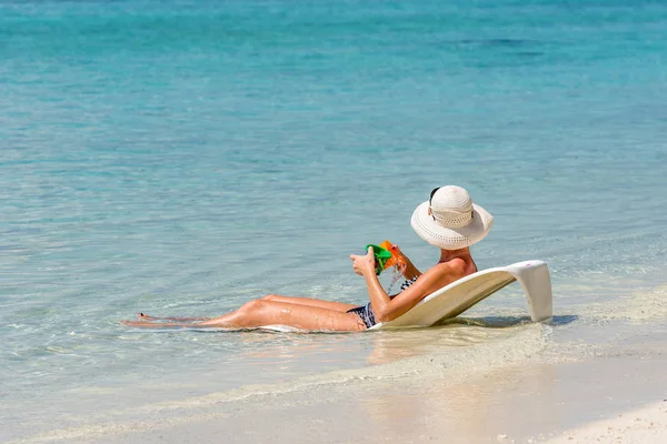 Frau liegt auf einem Liegestuhl im Ozean, Malediven, Indischer Ozean. Kopierraum für Text. — Stockfoto