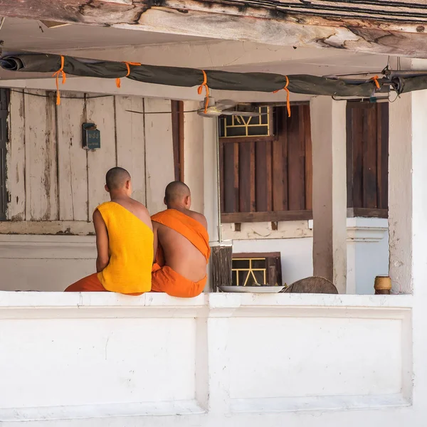 Dva buddhističtí mniši na verandě budova, Louangphabang, Laos. Kopírovat prostor pro text. — Stock fotografie