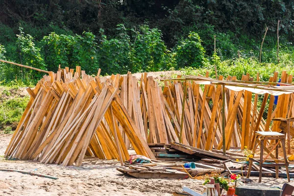 Wooden boards on the bank of the river Nam Khan in Louangphabang, Laos. Close-up. — Stock Photo, Image