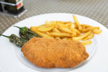 Kızarmış et kırıntıları ile patates kızartması bir tabakta beyaz, Siurana, Catalunya, İspanya olarak. Yakın çekim.