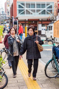 Tokyo, Japonya - 31 Ekim 2017: Yaşlı kadın bir şehir sokak üzerinde. Dikey. Metin için yer kopyalayın