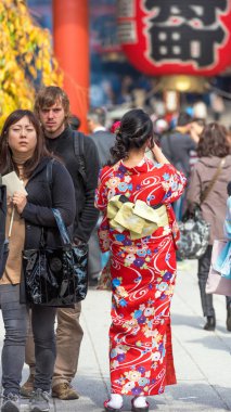 Tokyo, Japonya - 31 Ekim 2017: Kız bir şehir sokak üzerinde kırmızı bir kimono. Dikey. Arkadan Görünüm