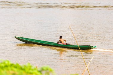 Luang Prabang, Laos - 11 Ocak 2017: Bir çocuk Nam Han Nehri üzerinde bir tekne. Metin için yer kopyalayın.