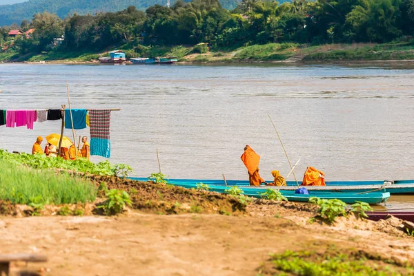 Luang Prabang, Laos - 11. ledna 2017: Mniši v lodi na řece řeky Nam Khan. Kopírovat prostor pro text. — Stock fotografie