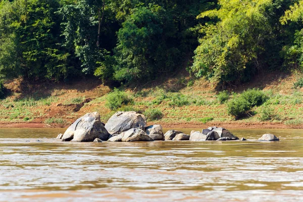 Uitzicht van de stenen op de rivier Nam Khan, Luang Prabang, Laos. Ruimte voor tekst kopiëren. — Stockfoto