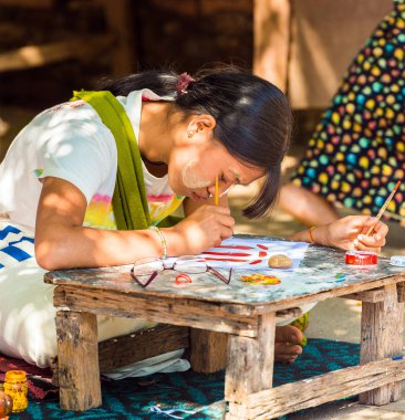 Bagan, Myanmar - 1 Aralık 2016: Kız bir şehir sokak boyuyor. Yakın çekim.