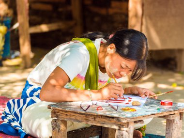 Bagan, Myanmar - 1 Aralık 2016: Kız bir şehir sokak boyuyor. Yakın çekim.