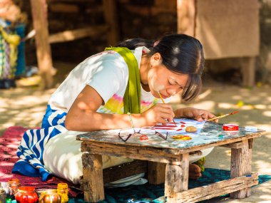 Bagan, Myanmar - 1 Aralık 2016: Kız bir şehir sokak boyuyor. Yakın çekim.