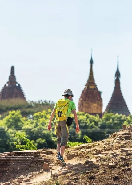 Mannen klättrar berget i Bagan, Myanmar. Kopiera utrymme för text. Vertikal. — Stockfoto