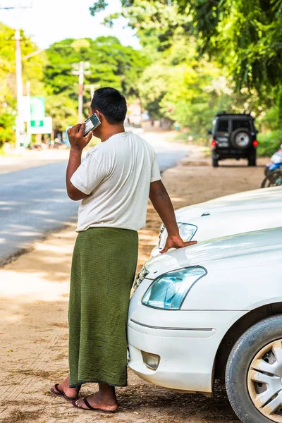 Bagan, Μιανμάρ - 1η Δεκεμβρίου 2016: Ο άνθρωπος που μιλάμε στο τηλέφωνο για μια πόλη δρόμου. Αντιγράψτε το χώρο για το κείμενο. Κάθετη. — Φωτογραφία Αρχείου
