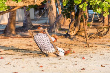 Bir hamakta Male, Maldivler kum plajındaki oturan adam. Metin için yer kopyalayın. 