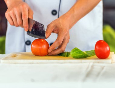 Bir aşçı, bir kesme tahtası üzerinde Hanoi, Vietnam için domates keser. Yakın çekim.