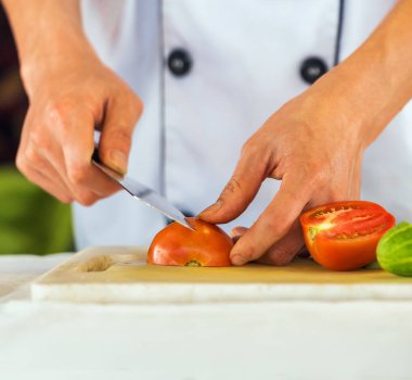 Bir aşçı, bir kesme tahtası üzerinde Hanoi, Vietnam için domates keser. Yakın çekim.