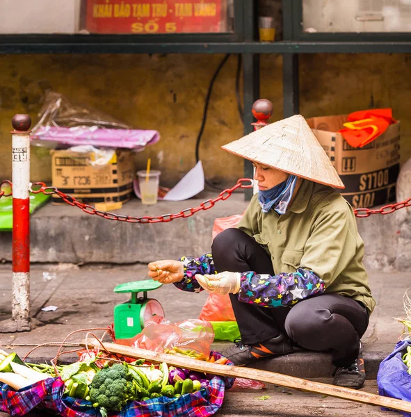 越南河内-2016年12月16日: 一名妇女在当地市场销售蔬菜。特写. — 图库照片