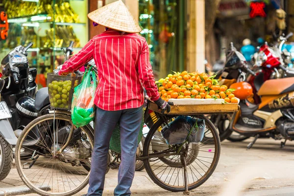 A man sells tangerines in the local market in Hanoi, Vietnam. Copy space for text.