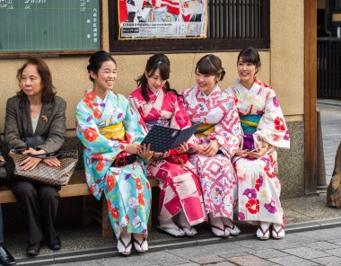 Kyoto, Japonya - 7 Kasım 2017: Bir grup kızı bir bankta bir kimono Sit. Metin için yer kopyalayın.  